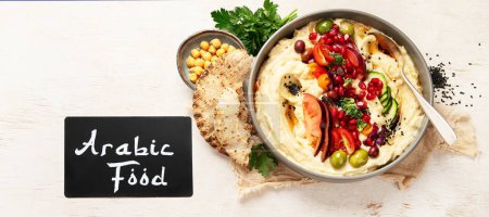Photo for Hummus in a plate with vegetables and seesam. Dish of chickpeas, pita. A vegetarian dish on a light background. Top view. Panorama. - Royalty Free Image