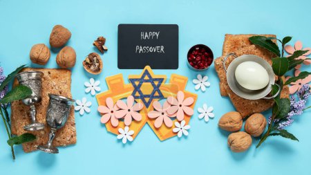 Foto de Concepto de celebración pascual. Matzah, nogal kosher rojo y flores hermosas de primavera sobre un fondo azul. Pan judío ritual tradicional. - Imagen libre de derechos