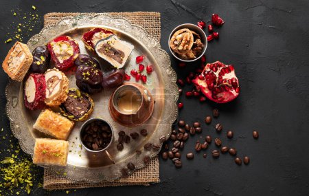 Photo for Hot tasty coffee with various pieces of turkish delight desets on a dark background. Traditional arabian food. Top view, copy space - Royalty Free Image