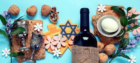 Téléchargez les photos : Concept de célébration de la Pâque. Matzah, noyer casher rouge et printemps belles fleurs sur un fond bleu. Pain juif rituel traditionnel. Panorama. - en image libre de droit