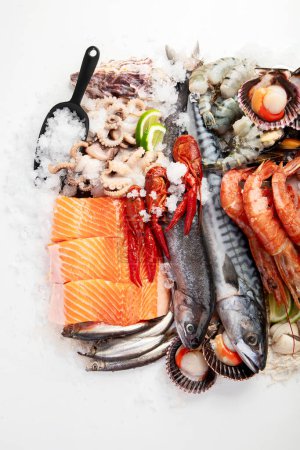 Foto de Varios platos de mariscos y peces. Concepto de comida saludable sobre fondo blanco, vista superior. - Imagen libre de derechos