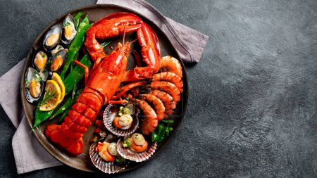 Photo for Big red lobster on plate with shrimp and mussels with lemon, souce pesto and bread. Seafood concept. Top view, copy space - Royalty Free Image