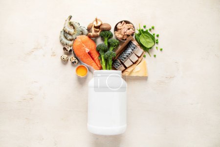 Foto de Fuentes naturales de vitamina D (pescado, queso, huevos, setas, gambas) sobre un fondo blanco. Vista superior. - Imagen libre de derechos