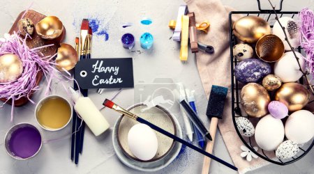 Foto de Feliz Pascua, pintando huevos. Pinturas, bolígrafos, decoraciones para colorear huevos para las vacaciones en un fondo blanco... - Imagen libre de derechos