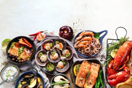Téléchargez les photos : Ensemble de plats de fruits de mer sur fond bois clair. Vue du dessus, espace de copie - en image libre de droit