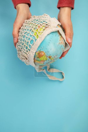 Foto de Mano sosteniendo globo sobre fondo azul. Protección del medio ambiente. Vista superior, espacio de copia - Imagen libre de derechos