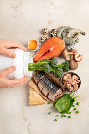 Téléchargez les photos : Sources naturelles de vitamine D (poisson, fromage, œufs, champignons, crevettes) sur fond blanc. Vue du dessus. - en image libre de droit