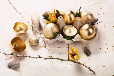 Téléchargez les photos : Élégant concept de Pâques aux œufs dorés. Oeufs en or de Pâques avec des fleurs sur fond clair. Bonne carte de Pâques. Vue du dessus. - en image libre de droit