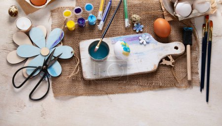 Téléchargez les photos : Joyeux Pâques, peindre des œufs. Peintures, stylos, décorations pour la coloration des œufs pour les vacances sur un fond blanc. Vue du dessus. - en image libre de droit