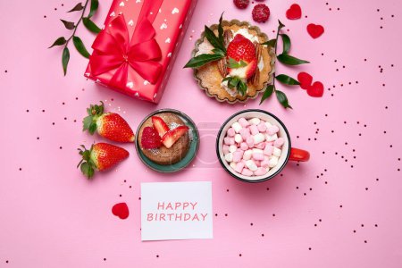 Photo for Festive pink background with cupcake, strawberries, chocolates, hot drink. Birthday celebration. Top view - Royalty Free Image