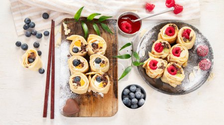 Photo for Asian sweet sushi pancake. Rolls with cream cheese berry and fruits. Top view - Royalty Free Image