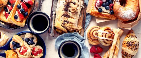 Photo for Table with various pastries and coffe cups on light backround. Top view. Panorama. - Royalty Free Image