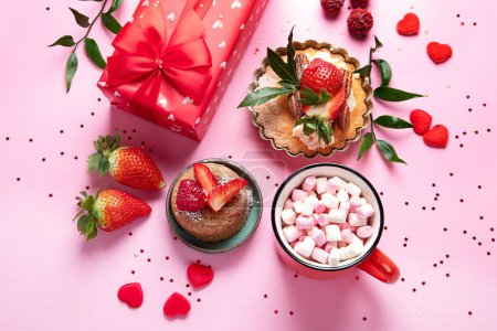 Téléchargez les photos : Fond rose festive avec cupcake, fraises, chocolats, boisson chaude. Fête d'anniversaire. Vue du dessus - en image libre de droit