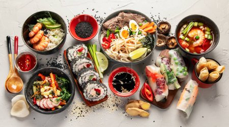 Foto de Varios comida asiática. Set de cocina japonesa. Sushi, ramen, rollitos de primavera. Vista superior. - Imagen libre de derechos