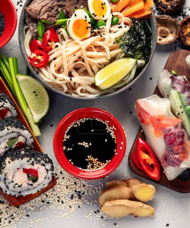Foto de Varios comida asiática. Set de cocina japonesa. Sushi, ramen, rollitos de primavera. Vista superior. - Imagen libre de derechos
