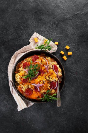 Foto de Comida híbrida de moda. Pizza de macarrones y queso sobre fondo oscuro. Vista superior - Imagen libre de derechos