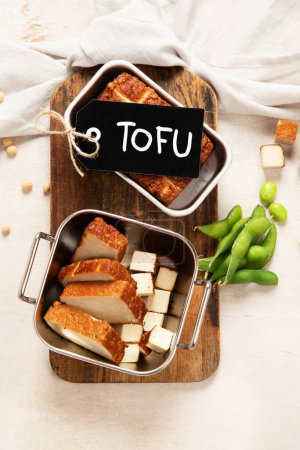 Photo for Soy food. Baked tofu cheese on a board, soybeans. Vegan product. Top view - Royalty Free Image