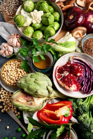 Foto de Comida vegana. Pimienta, brócoli, col, ajo, champiñones, granada sobre un fondo oscuro. Vista superior - Imagen libre de derechos