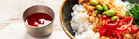 Foto de Comida vegana. Carne de soja, arroz blanco, frijoles, pimiento rojo sobre fondo de madera clara. Banner - Imagen libre de derechos