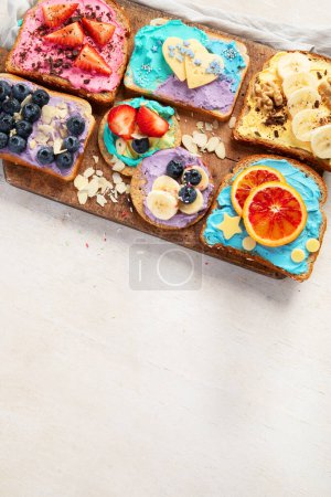 Photo for Sweet breakfast. Colorful toasts with fruits and berries. Children's food concept. Top view, copy space - Royalty Free Image