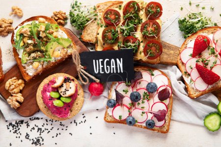 Foto de Desayuno con verduras. tostadas, tomate, pepino, rábano, aguacate. Concepto de comida saludable vegana. Vista superior - Imagen libre de derechos