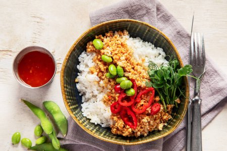 Foto de Comida vegana. Carne de soja, arroz blanco, frijoles, pimiento rojo sobre fondo de madera clara. Vista superior - Imagen libre de derechos