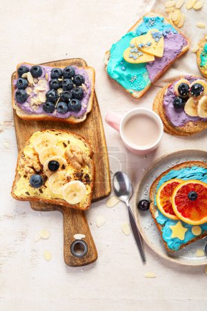 Photo for Sweet breakfast with cup of cocoa. Toast with cream cheese, banana, strawberries, blueberries. Top view - Royalty Free Image