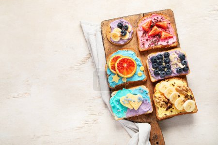 Foto de Dulce desayuno. Brindis coloridos con frutas y bayas. Concepto de comida infantil. Vista superior, espacio de copia - Imagen libre de derechos