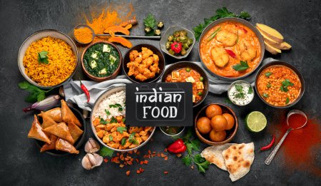 Téléchargez les photos : Plats de cuisine indienne. bols et assiettes avec de la nourriture indienne sur fond sombre. - en image libre de droit