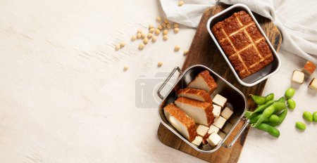 Photo for Soy food. Baked tofu cheese on a board, soybeans. Vegan product. Top view, copy space, banner - Royalty Free Image