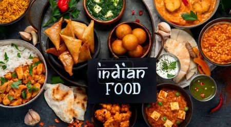 Téléchargez les photos : Plats de cuisine indienne. bols et assiettes avec de la nourriture indienne sur fond sombre. - en image libre de droit