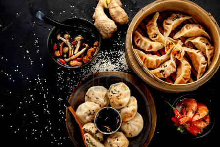 Photo for Chinese dumplings, soy sauce, mushrooms on dark background. traditional asian food concept. Top view - Royalty Free Image
