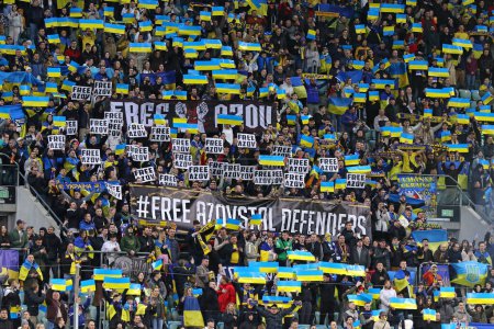 Téléchargez les photos : Wroclaw, Pologne - 26 mars 2024 : Les supporters ukrainiens avec une bannière Free Azovstal Defenders montrent leur soutien lors du match éliminatoire UEFA EURO 2024 Ukraine v Islande à l'aréna Tarczynski à Wroclaw - en image libre de droit