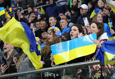 Foto de Wroclaw, Polonia - 26 de marzo de 2024: Partidarios ucranianos con banderas muestran su apoyo durante el partido de play-off UEFA EURO 2024 Ucrania v Islandia en Tarczynski Arena en Wroclaw. Ucrania ganó 2-1 - Imagen libre de derechos