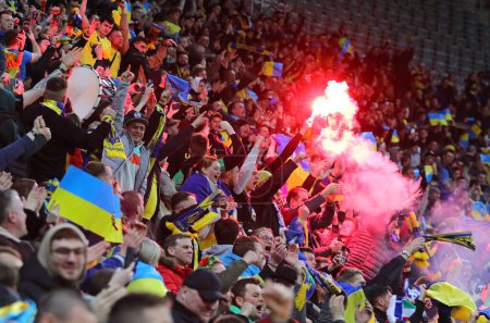Téléchargez les photos : Wroclaw, Pologne - 26 mars 2024 : Les ultra supporters ukrainiens (ultras) brûlent des fusées éclairantes et montrent leur soutien lors du match éliminatoire UEFA EURO 2024 Ukraine contre Islande à l'aréna Tarczynski. L'Ukraine a gagné 2-1 - en image libre de droit