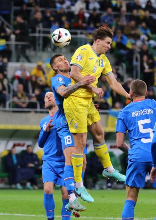 Téléchargez les photos : Wroclaw, Pologne - 26 mars 2024 : Illia Zabarnyi d'Ukraine (en jaune) se bat pour un ballon avec Daniel Leo Gretarsson d'Islande (# 18) lors de leur match éliminatoire UEFA EURO 2024 à l'aréna Tarczynski - en image libre de droit
