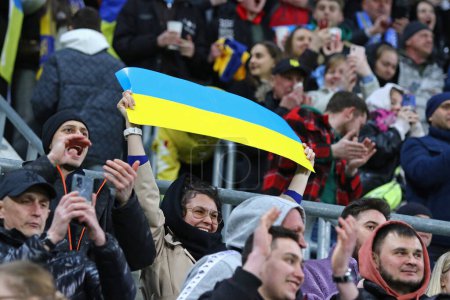 Téléchargez les photos : Wroclaw, Pologne - 26 mars 2024 : Les supporters ukrainiens avec des drapeaux montrent leur soutien lors du match éliminatoire UEFA EURO 2024 Ukraine contre Islande à l'aréna Tarczynski à Wroclaw. L'Ukraine a gagné 2-1 - en image libre de droit