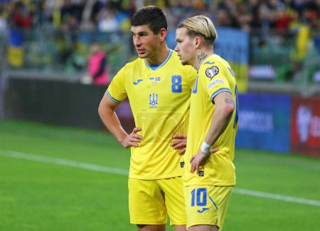 Téléchargez les photos : Wroclaw, Pologne - Mars 26, 2024 : Ruslan Malinovskyi (L) et Mykhailo Mudryk de l'Ukraine se préparent à effectuer un coup franc lors du match Play-off EURO 2024 de l'UEFA contre l'Islande à l'aréna Tarczynski - en image libre de droit