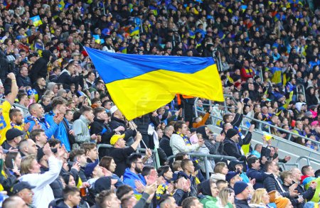 Téléchargez les photos : Wroclaw, Pologne - 26 mars 2024 : Les supporters ukrainiens avec des drapeaux montrent leur soutien lors du match éliminatoire UEFA EURO 2024 Ukraine contre Islande à l'aréna Tarczynski à Wroclaw. L'Ukraine a gagné 2-1 - en image libre de droit