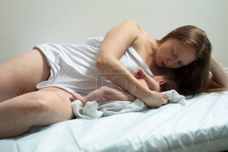 Foto de Una mujer con un bebé recién nacido descansa. Primeros minutos después de nacer - Imagen libre de derechos