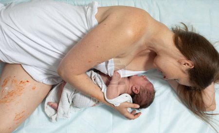 Téléchargez les photos : Une femme avec un nouveau-né se repose. Premières minutes après l'accouchement - en image libre de droit