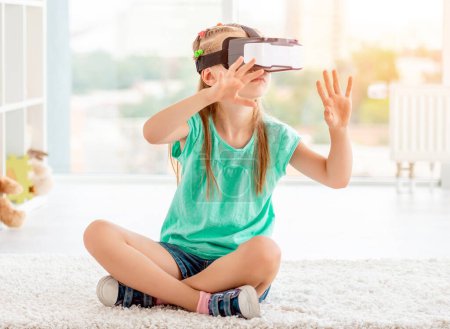 Téléchargez les photos : Petite fille portant des lunettes de réalité virtuelle dans la salle de jeu - en image libre de droit