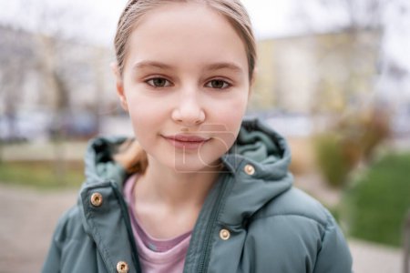 Foto de Retrato callejero de niña preadolescente en la ciudad con fondo borroso. Lindo niño femenino al aire libre en otoño - Imagen libre de derechos