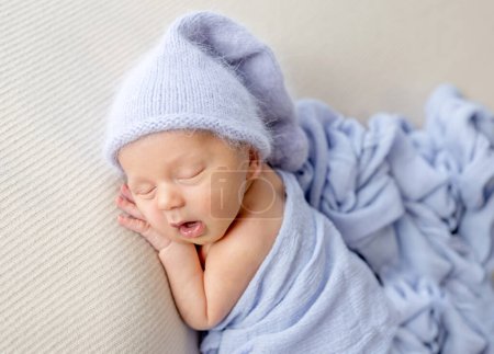 Photo for Newborn baby boy sleeping with mouth open wearing hat. Little infant child napping - Royalty Free Image