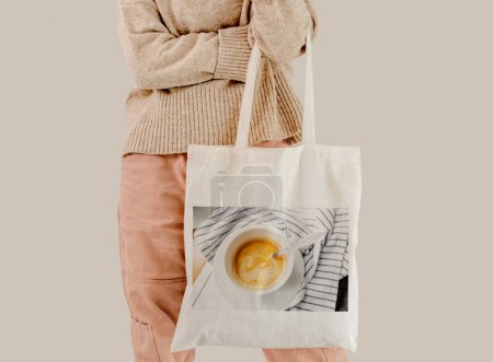 Foto de Girl holding cotton linen eco bag with coffee cup mug design. Woman with environment friendly reusing shopping handbag - Imagen libre de derechos