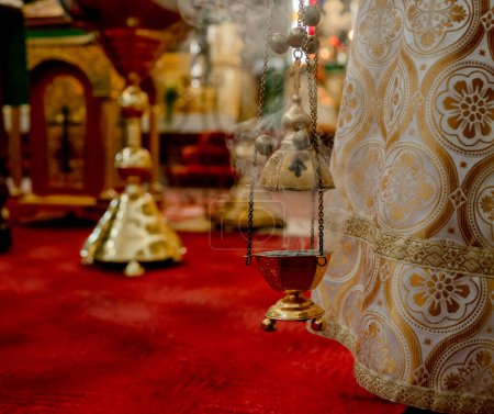 Téléchargez les photos : Les prêtres encens dans une pendaison dans l'Église orthodoxe. Arôme de cuivre avec des charbons brûlants à l'intérieur et de la fumée avec un arôme parfumé. Le concept de l "Église orthodoxe. - en image libre de droit