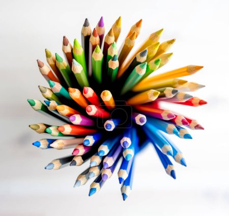 Foto de Lápices de colores agudos en papel acuarela, vista desde arriba. Paleta de crayones multicolor para inspiración artística - Imagen libre de derechos