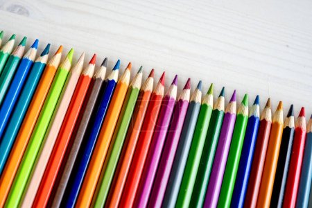Foto de Colorful pencils lying on watercolor paper closeup. Multicolor crayons pallete for artist inspiration and hobby - Imagen libre de derechos