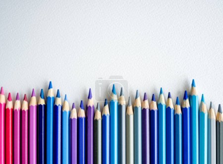 Photo for Pencils with blue, purple and pink color lying on watercolor paper closeup. Multicolor crayons pallete with copy space for artist inspiration and hobby - Royalty Free Image