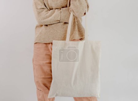 Foto de Girl holding cotton linen eco bag ivory color mockup. Woman with environment friendly shopping handbag with empty copy space for business - Imagen libre de derechos